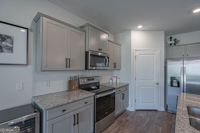 110 Cole St, Pooler, GA 31322 - kitchen featuring light stone counters, appliances with stainless steel finishes, gray cabinets, dark wood-type flooring, and backsplash