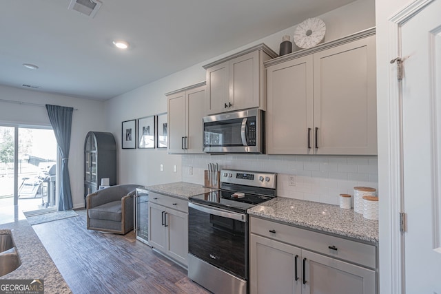 110 Cole St, Pooler, GA 31322 - kitchen with visible vents, decorative backsplash, dark wood-style flooring, appliances with stainless steel finishes, and gray cabinetry