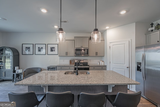 110 Cole St, Pooler, GA 31322 - kitchen with stainless steel appliances, gray cabinetry, a sink, and a kitchen bar