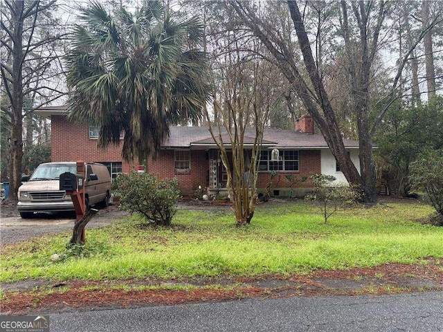 view of front of property featuring brick siding and a chimney
