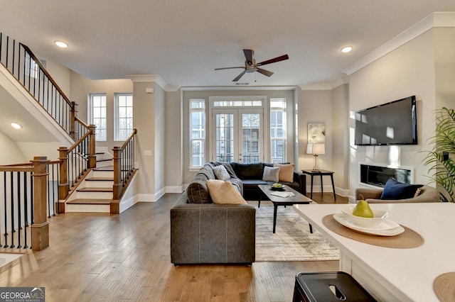 606 Broadview Ter NE, Atlanta, GA 30324 - living area with crown molding, stairs, wood finished floors, baseboards, and a ceiling fan