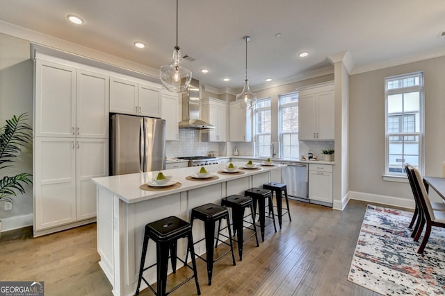 606 Broadview Ter NE, Atlanta, GA 30324 - kitchen featuring ornamental molding, baseboards, wall chimney range hood, light countertops, and appliances with stainless steel finishes