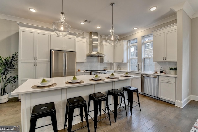 606 Broadview Ter NE, Atlanta, GA 30324 - kitchen with light countertops, appliances with stainless steel finishes, wall chimney exhaust hood, and a breakfast bar area