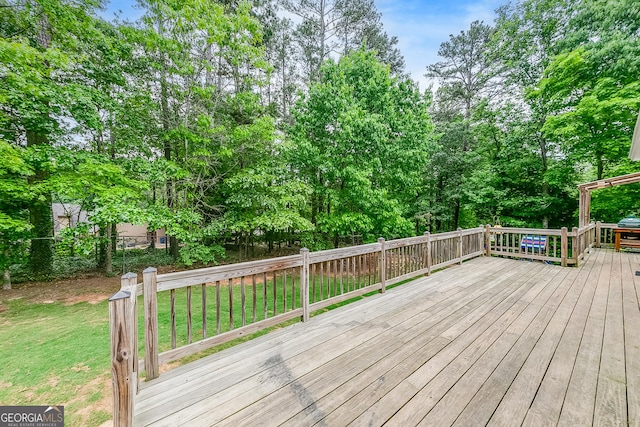 wooden deck featuring a lawn and fence