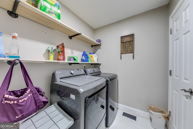 washroom with laundry area, visible vents, tile patterned floors, baseboards, and washer and dryer