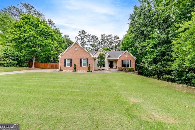 ranch-style home featuring fence, a front yard, and brick siding