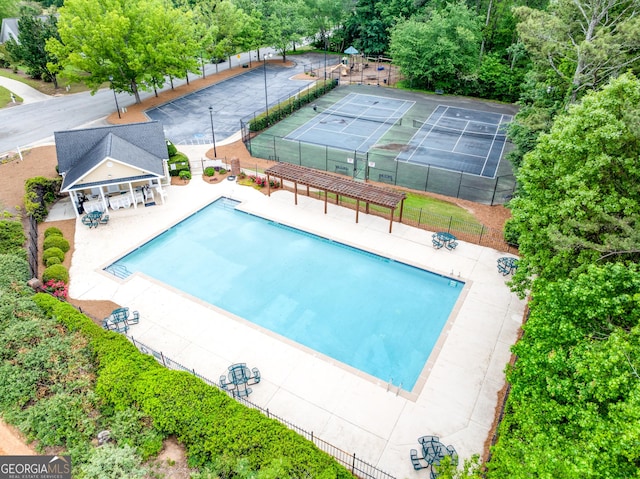 community pool with fence and a patio area