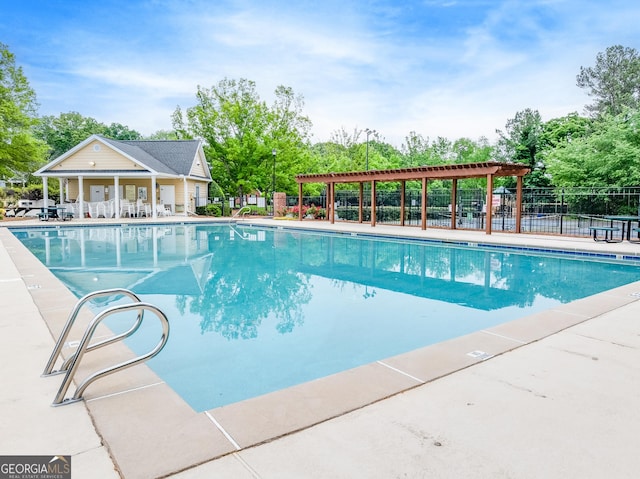 pool with a patio area and fence