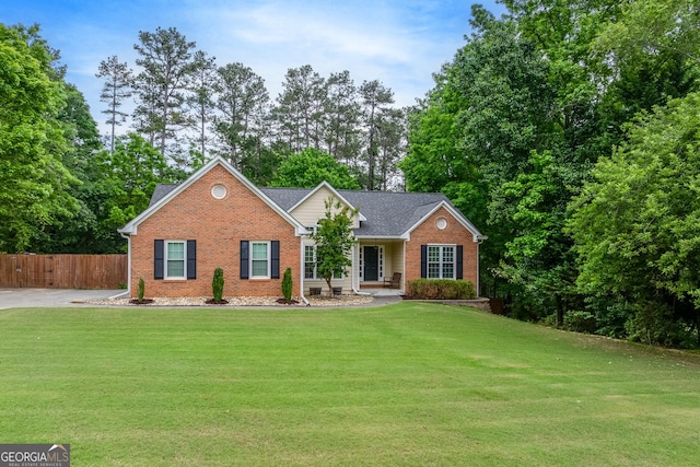 view of front of property with fence, a front yard, and brick siding
