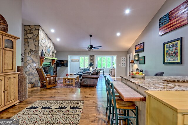 interior space with recessed lighting, ceiling fan, light wood finished floors, and a fireplace