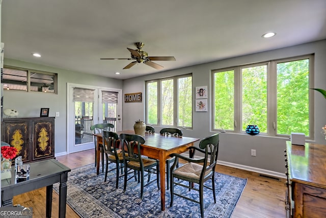 dining room with plenty of natural light, ceiling fan, wood finished floors, and visible vents