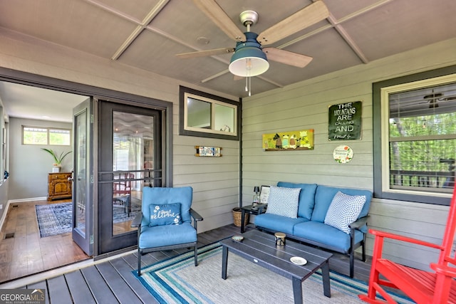 wooden deck featuring an outdoor living space and a ceiling fan
