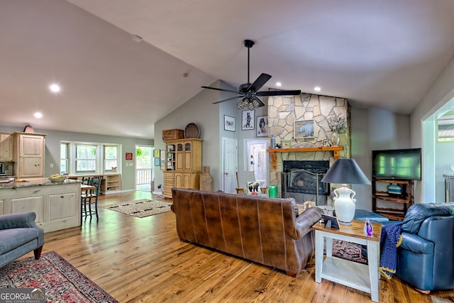 living area with a ceiling fan, recessed lighting, light wood finished floors, and a fireplace