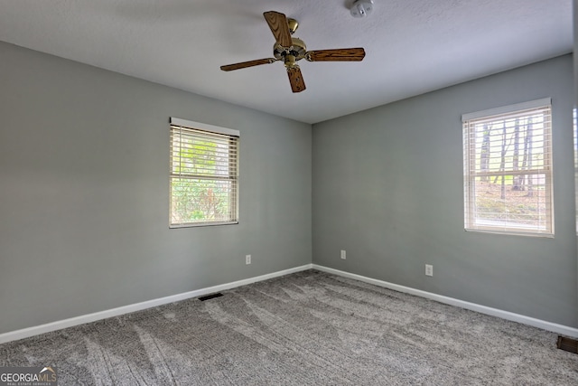 spare room featuring baseboards, a ceiling fan, carpet flooring, and visible vents