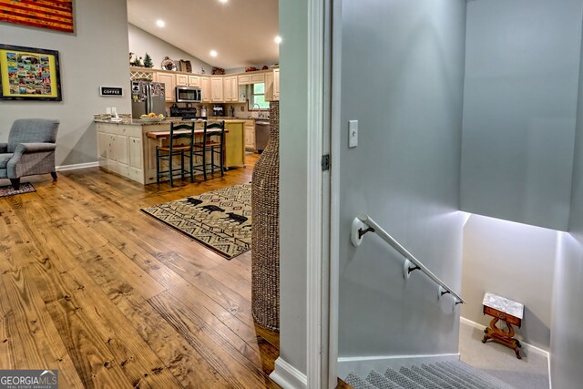 interior space with recessed lighting, baseboards, light wood-style flooring, and lofted ceiling
