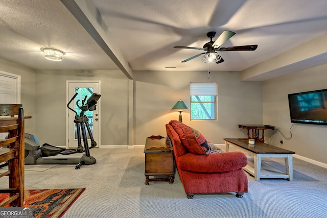 living area with ceiling fan, a textured ceiling, visible vents, carpet floors, and baseboards