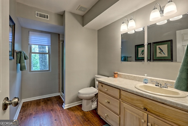 full bathroom featuring baseboards, toilet, wood finished floors, and visible vents