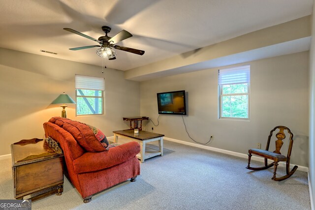 carpeted living area with visible vents, baseboards, ceiling fan, and a healthy amount of sunlight