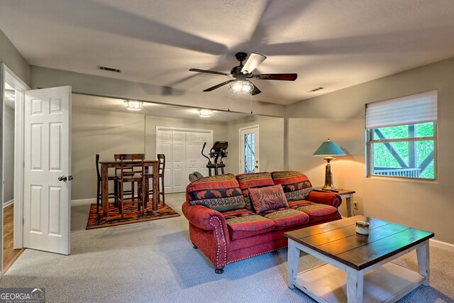 living area with visible vents, carpet, ceiling fan, and baseboards