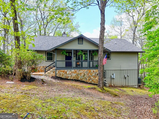 back of property with central air condition unit, a shingled roof, and a chimney