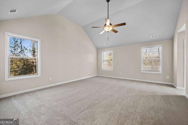 empty room with visible vents, a ceiling fan, carpet, and vaulted ceiling