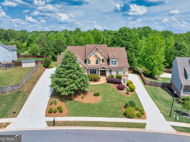 view of front facade with fence, driveway, and a front lawn