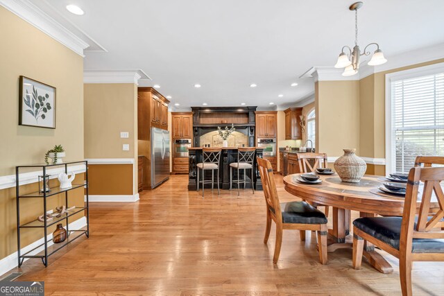 dining area with crown molding, recessed lighting, light wood-style flooring, and a chandelier