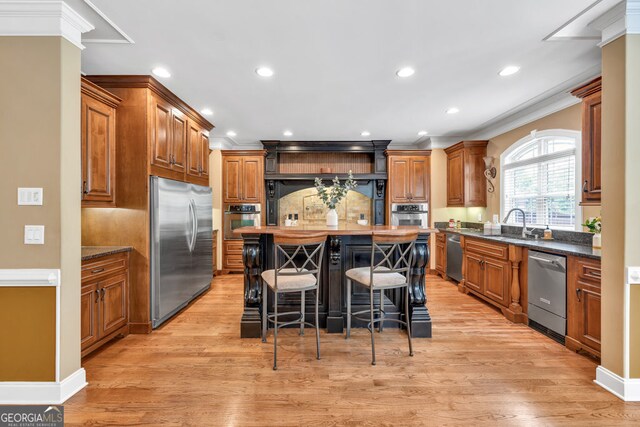 kitchen with a kitchen island, crown molding, appliances with stainless steel finishes, tasteful backsplash, and brown cabinets