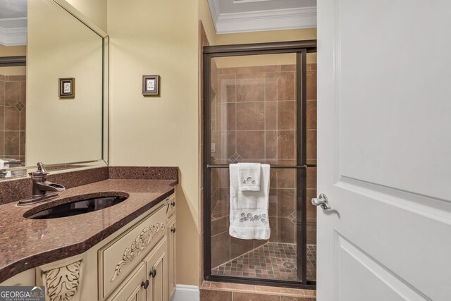 full bathroom featuring vanity, ornamental molding, and a shower stall