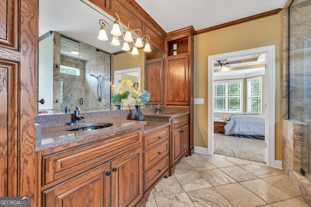 ensuite bathroom with crown molding, a sink, baseboards, and a stall shower