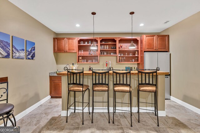 bar with decorative light fixtures, visible vents, baseboards, freestanding refrigerator, and recessed lighting