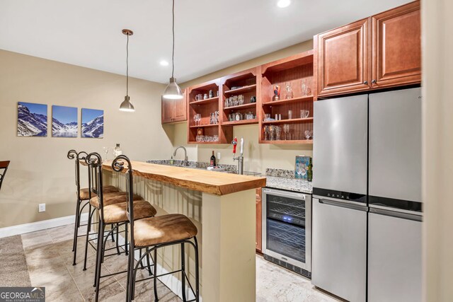kitchen featuring wooden counters, open shelves, freestanding refrigerator, wine cooler, and a breakfast bar