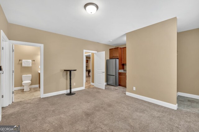 unfurnished living room with baseboards and light carpet