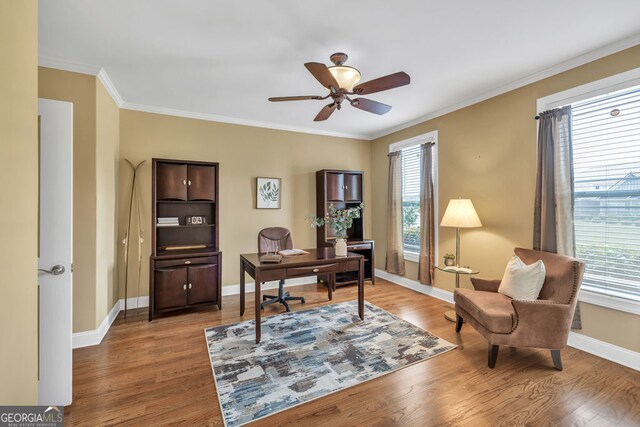office area featuring crown molding, ceiling fan, baseboards, and wood finished floors