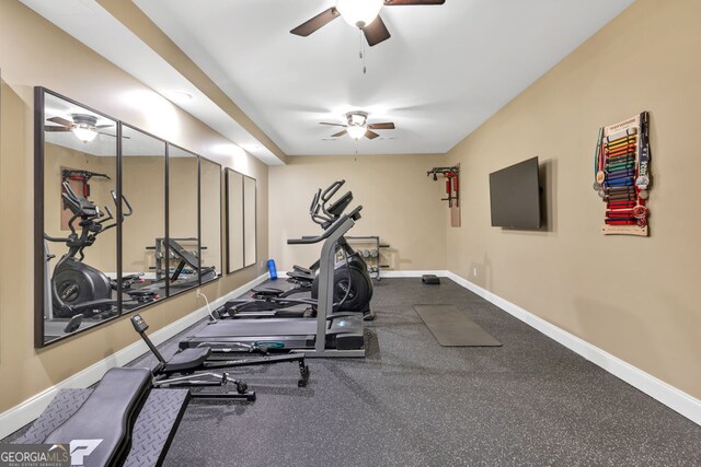 workout area featuring a ceiling fan and baseboards