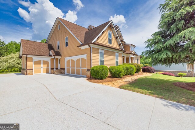 view of home's exterior with a shingled roof, an attached garage, stone siding, concrete driveway, and a yard