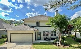 view of front of house featuring an attached garage, driveway, and a front yard