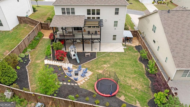 7730 Tiberon Pkwy, Cumming, GA 30028 - rear view of house featuring roof with shingles, a trampoline, a lawn, a fenced backyard, and a patio