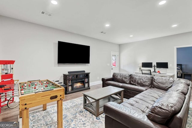 7730 Tiberon Pkwy, Cumming, GA 30028 - living room with recessed lighting, a glass covered fireplace, wood finished floors, and visible vents