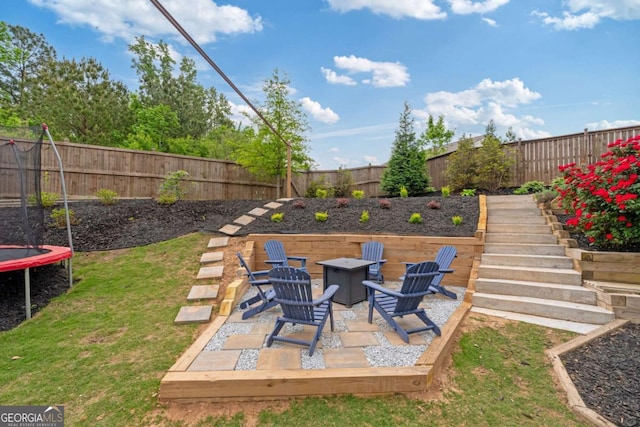 7730 Tiberon Pkwy, Cumming, GA 30028 - view of yard with a fenced backyard, a trampoline, and an outdoor fire pit