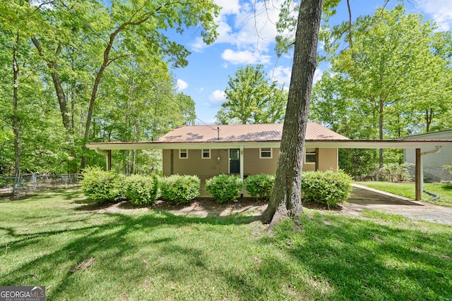 back of house featuring metal roof, fence, a yard, and a carport