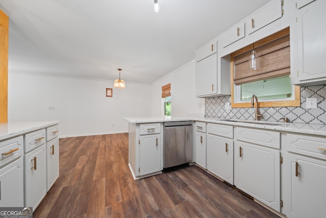 kitchen featuring stainless steel dishwasher, a peninsula, white cabinets, tasteful backsplash, and a sink