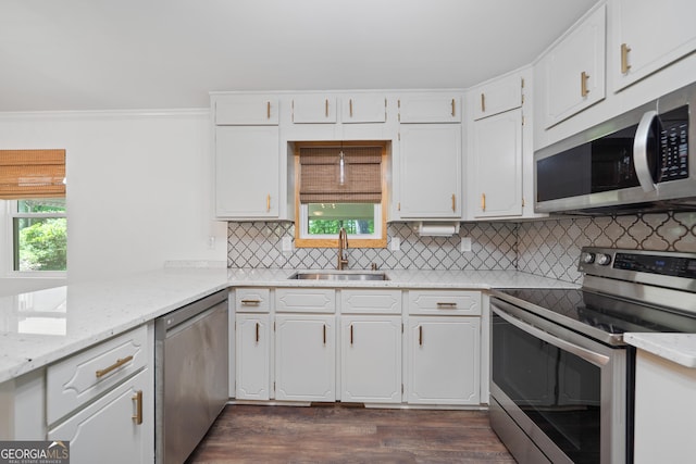 kitchen with a sink, appliances with stainless steel finishes, crown molding, and white cabinetry