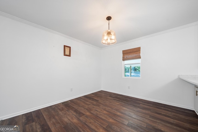 spare room with visible vents, ornamental molding, dark wood-style flooring, an inviting chandelier, and baseboards
