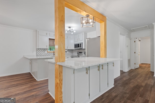 kitchen with crown molding, dark wood-type flooring, white cabinets, tasteful backsplash, and stainless steel appliances