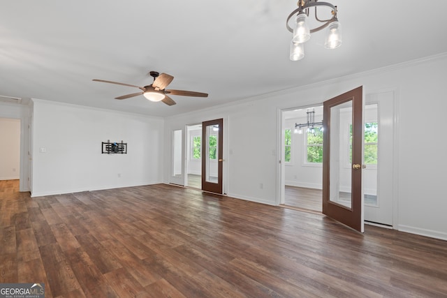 unfurnished living room featuring dark wood-style floors, ornamental molding, and ceiling fan with notable chandelier