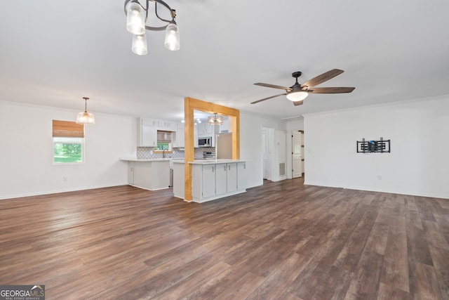 unfurnished living room with baseboards, dark wood finished floors, and ceiling fan with notable chandelier