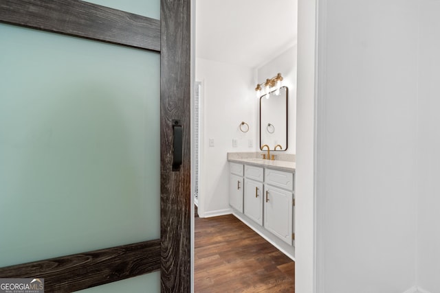 bathroom featuring baseboards, wood finished floors, and vanity
