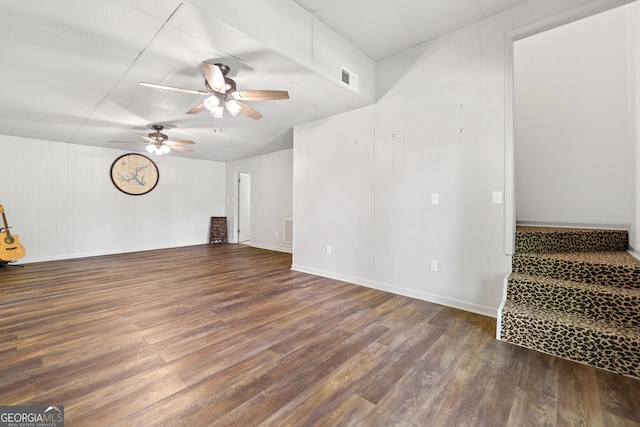 unfurnished living room with visible vents, stairs, wood finished floors, baseboards, and ceiling fan