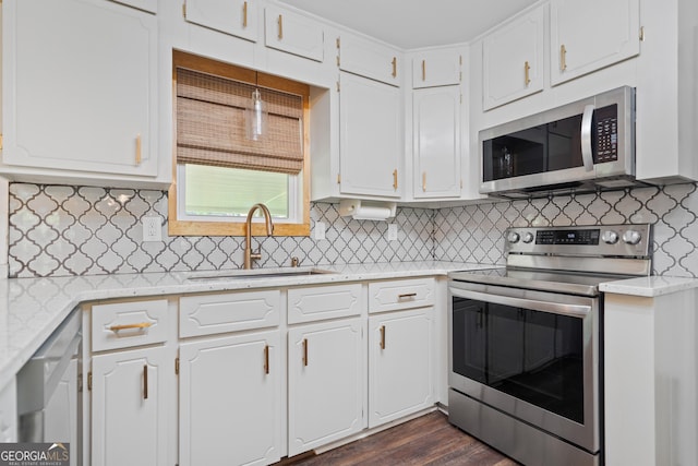 kitchen with light countertops, white cabinets, appliances with stainless steel finishes, and a sink